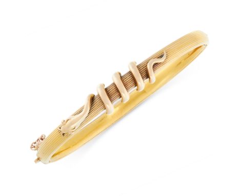 AN ANTIQUE SNAKE BANGLE, LATE 19TH CENTURY in yellow gold, the reeded band with applied motif depicting a snake coiled around