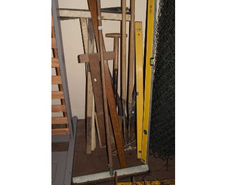 Quantity of assorted tools to include spirit levels, rakes, T squares and others