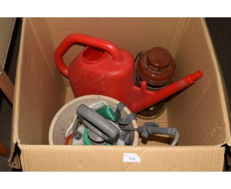 A weed sprayer, watering can and paraffin lamp