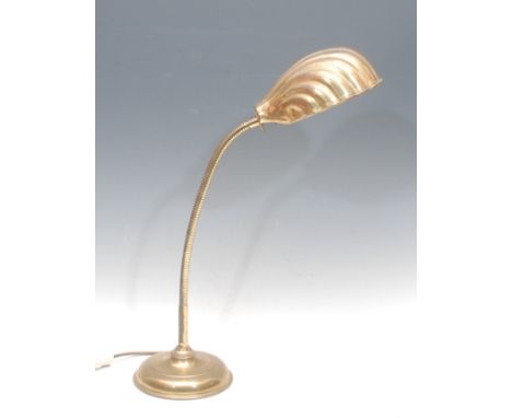 An early 20th century brass desk lamp, scallop shell shade, circular base, 64cm high fully extended, c. 1920