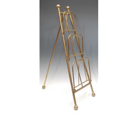 An early 20th century brass easel magazine rack, each of the three tiers moving 180 degrees, orb finials, 80cm high overall