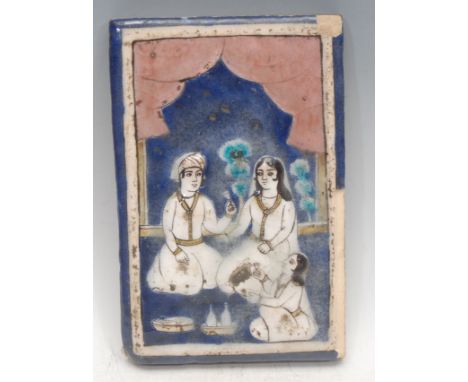 A 19th century North Indian or Persian bas-relief stone glaze tile, cast with a family sharing soma in a domestic setting, pa