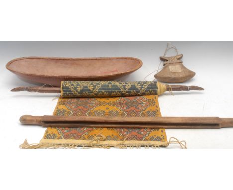 An Indonesian Toraja carved wooden and bone betel nut box; a tribal hand carved oval bowl with wickerwork border; a wall hang