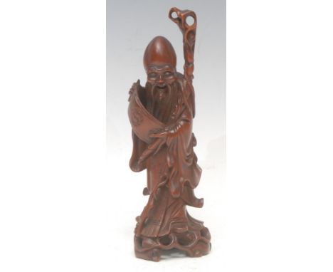 A Chinese boxwood figure, carved as Shou Lao, he stands, holding a scroll, 20cm high, 19th/early 20th century