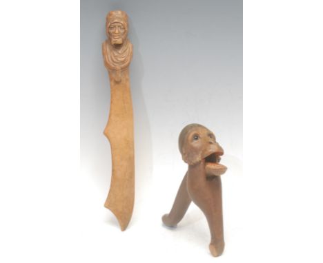 A Black Forest novelty lever-action nut cracker, carved as the head of a monkey, 18cm long, c.1900; a Black Forest pafge turn