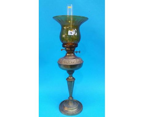 An oil lamp with amber coloured shade.