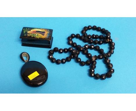 A jet style pendant and necklace along with a Continental papier mache snuff box.