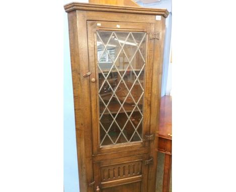 An Oak standing corner cabinet with leaded glazed door.