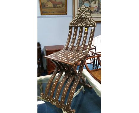 A Middle Eastern folding chair inlaid with mother of pearl.