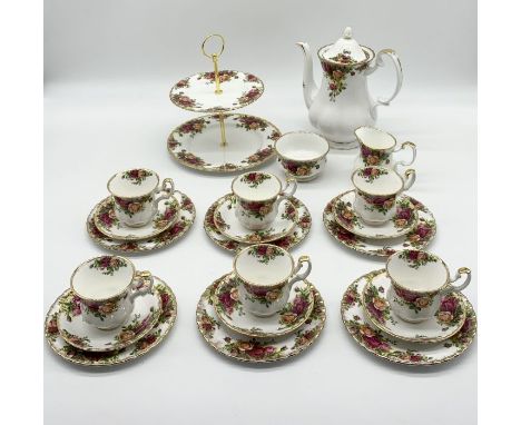 A Royal Albert Country Roses part tea set including six trios, teapot, sugar bowl, cake stand, milk jug.