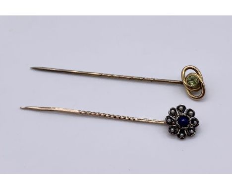 A 9ct gold stick pin set with a peridot along with one other unmarked pin set with seed pearls and cabochon lapis lazuli