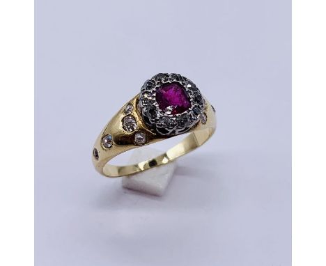 An unmarked (probably 18ct gold) diamond and ruby ring set with diamonds to the shoulders