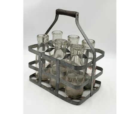 A collection of vintage milk bottles in galvanised carry case