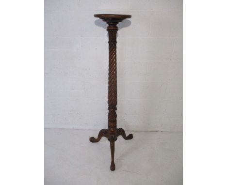 A mahogany torchere with barley twist column and tripod base