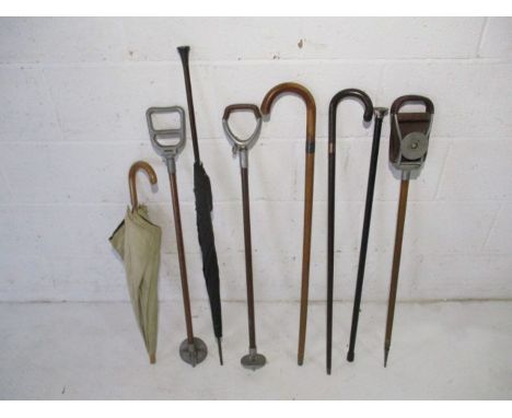 A collection of walking sticks, vintage umbrella's and shooting sticks including silver mounted and gold collared