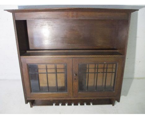 A large inlaid oak smokers cabinet with leaded light features 