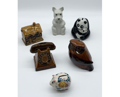 A collection of ceramic money boxes including Wade, Szeiler etc.
