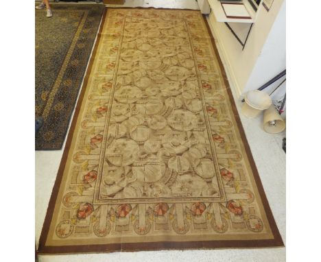 A machine made early to mid-20th Century carpet, the centre field with circular and geometric design in cream, taupe and madd