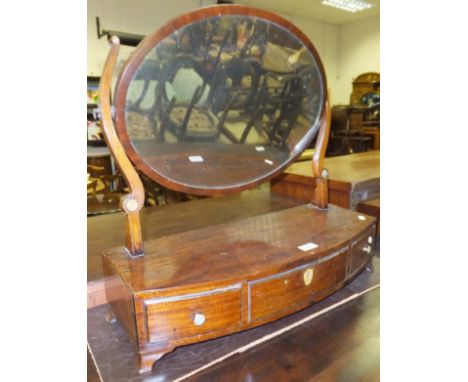 A 19th Century mahogany toilet mirror, the oval glass above a bow front with three drawers