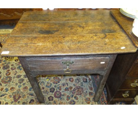 An 18th Century Continental (possibly French) oak side table, the shaped top above a single drawer, on square chamfered suppo