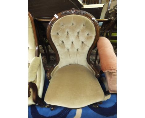 A Victorian mahogany framed salon chair in pale yellow button back upholstery, the shaped legs terminating in white china cas