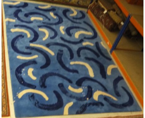 A modern machine woven wool carpet with blue and white scroll decoration on a blue ground, 303 x 195cm