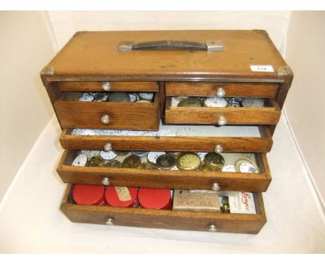 An engineer's tool box containing various pocket watch spares, to include enamel dials, etc