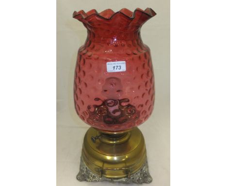 A 19th Century oil lamp with large cranberry and ribbon decorated glass shade (converted to electricity)