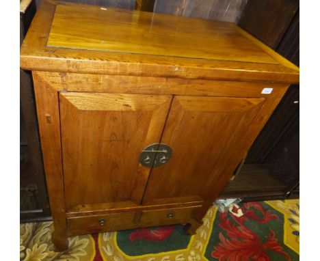 A Chinese elm two door cupboard enclosing shelf with two drawers below, brass handles and locking mechanism