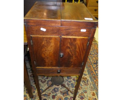 A Georgian mahogany square wash stand, the two section top opening to reveal toiletry holes, above a pair of doors over a sin