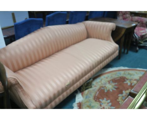 AN EARLY 20TH CENTURY MAHOGANY FRAMED HUMPBACKED SOFA in peach silk striped upholstery with overstuffed back and sides on rin