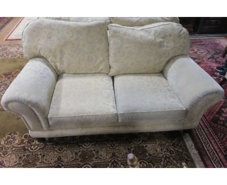 A MODERN LARGE TWO SEATER SOFA, the overstuffed scrolled sides fitted with loose back and seat cushions on bun feet with cast