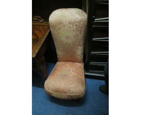 A VICTORIAN MAHOGANY FRAMED LOW CHAIR, with pink silk and embroidered back on seat and ring turned supports