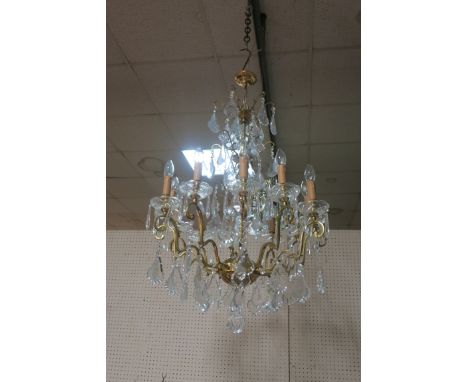 A CONTINENTAL STYLE GILT BRASS AND CUT GLASS TWELVE LIGHT CHANDELIER, the central brass stem with glass shades circular pans 