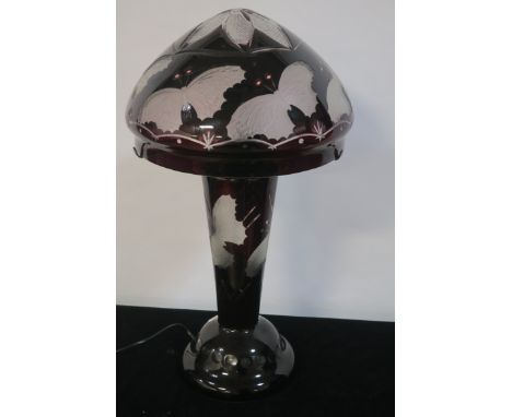 AFTER EMILE GALLE, a ruby and clear glazed table lamp decorated with butterflies, the dome shade on a circular tapering stem 