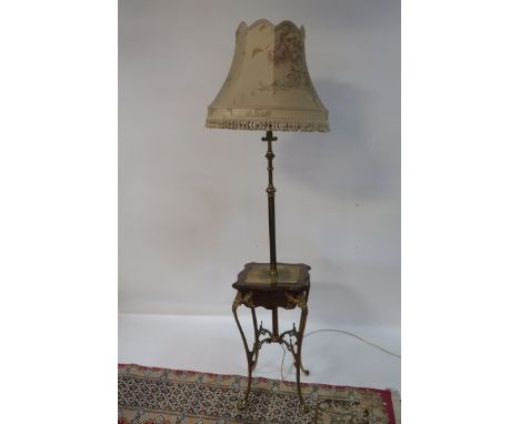 A CONTINENTAL STYLE MAHOGANY AND BRASS FRAMED LAMP TABLE, the tubular brass stem fitted with a single light and silk shade ab