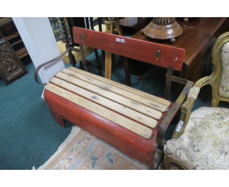 A METAL AND PINE GARDEN SEAT, modelled as a tractor bonnet with scroll arms, 129cms wide.