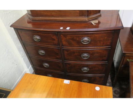 A GEORGIAN STYLE MAHOGANY BOWED CABINET, the crossbanded top with reeded rim above a pair of hinged cupboard doors modelled a