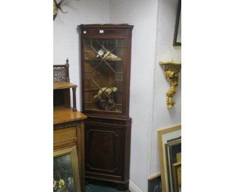 A GEORGIAN STYLE MAHOGANY FRAMAED CORNER CABINET, the dentil cornice above an astragal glazed door with outset base cupboard 