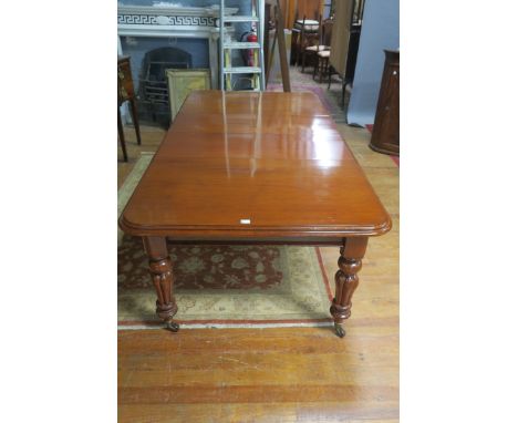 A 19th CENTURY MAHOGANY DINING ROOM TABLE, the rectangular top with rounded ends and moulded rim, raised on ring turned taper
