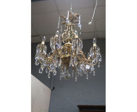 A CONTINENTAL STYLE GILT BRASS TEN LIGHT CHANDELIER, the acanthus shaped corona hung with pendent drops above the scrolled an
