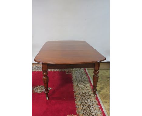A MAHOGANY DINING ROOM TABLE the rectangular top with rounded ends and moulded rim raised on four ring turned tapering suppor