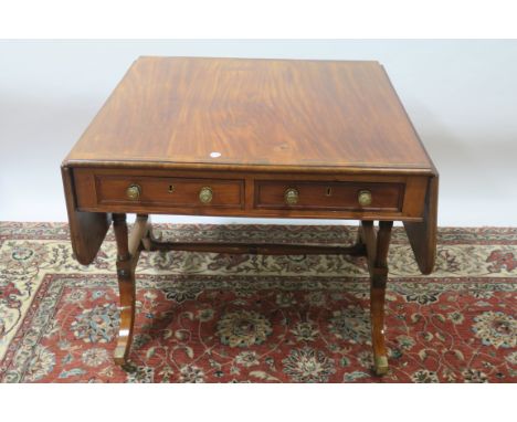 A 19TH CENTURY REGENCY STYLE MAHOGANY CROSSBANDED SOFA TABLE, the rectangular drop leaf top with moulded rim and rounded corn