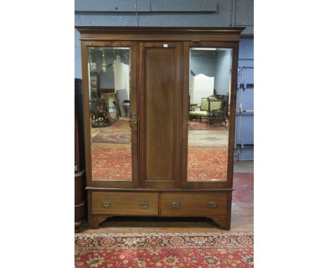 A MAHOGANY AND MARQUETRY INLAID THREE DOOR WARDROBE, the moulded cornice above a pair of bevelled glazed doors, opening to re