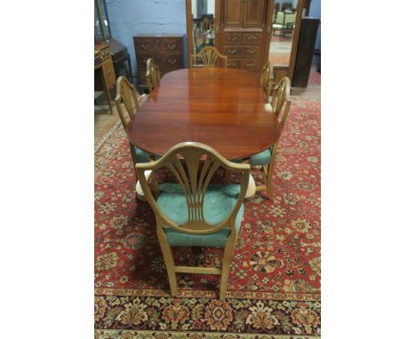 A MAHOGANY DINING ROOM SUITE comprising an oval top table with reeded rim raised on twin pillar supports with tripod legs, br