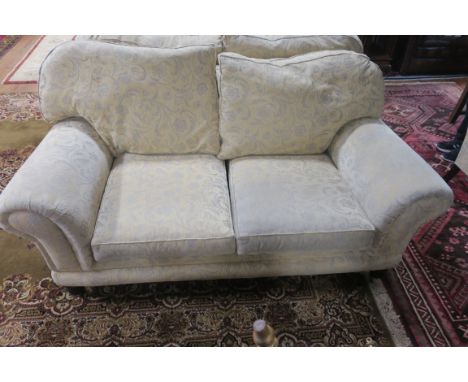 A MODERN LARGE TWO SEATER SOFA, the overstuffed scrolled sides fitted with loose back and seat cushions on bun feet with cast