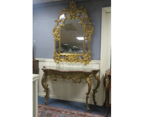 A CONTINENTAL STYLE GILT CONSOLE TABLE AND MIRROR, the scrolling foliate compartmented mirror headed by a pierced cartouche a