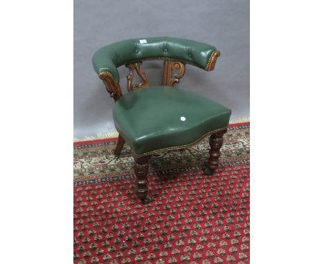 A VICTORIAN MAHOGANY AND GREEN LEATHER UPHOLSTERED  TUB SHAPED CHAIR, the buttoned upholstered padded top rail raised on foli