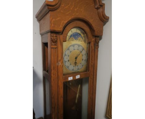 AN OAK LONGCASE CLOCK, the rectangular arched hood containing a brass and silvered dial with phases of the moon inscribed Rid