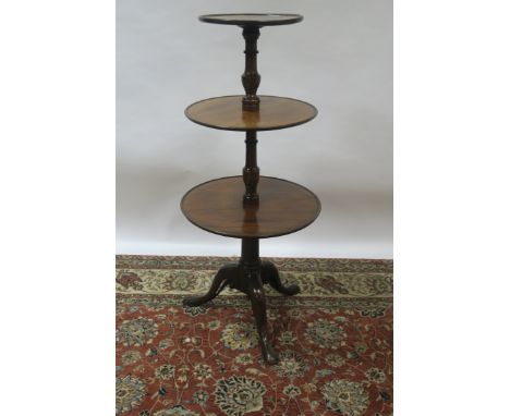 A VICTORIAN MAHOGANY THREE TIER DUMB WAITER, the circular graduating trays between on ring turned supports on tripod cabriole